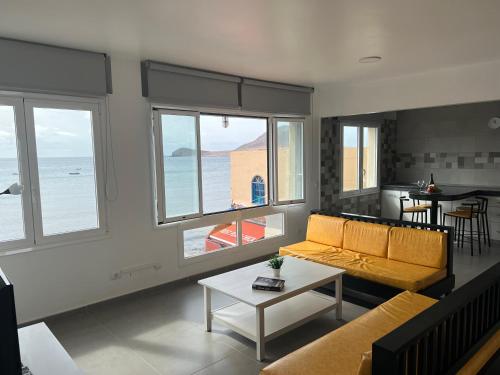 uma sala de estar com um sofá e uma mesa em Edificio Playa Chica em El Médano