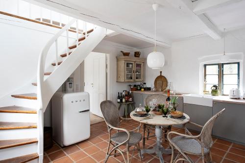 - une cuisine et une salle à manger avec une table et des chaises dans l'établissement Gartnerhuset på Kollerup, à Hadsten Stationsby