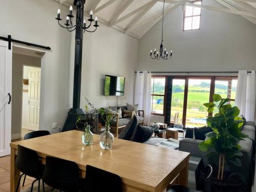 uma sala de estar com uma mesa de madeira e um sofá em Lalamanzi Trout Cottage - Solar Powered em Underberg