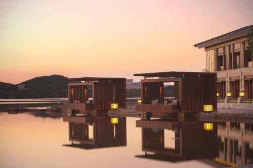 un grupo de edificios sobre una masa de agua en Yanqi Hotel, Managed by Kempinski en Huairou