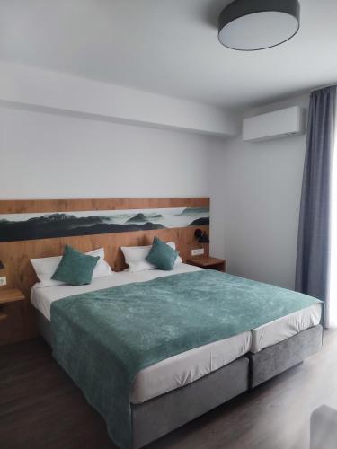 um quarto com uma cama grande e um cobertor verde em Hotel & Appartements Nice Garni em Ichenhausen