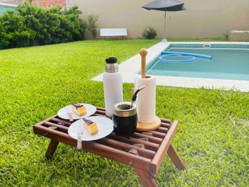 una mesa de picnic con comida junto a una piscina en Chito House en Buenos Aires