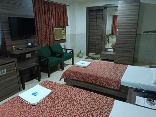 Habitación de hotel con 2 camas y TV en Hotel Orchid, en Guwahati