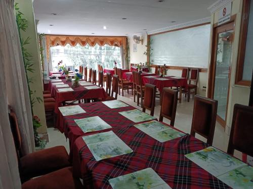 comedor con mesas y sillas y pizarra en Hotel Orchid, en Guwahati