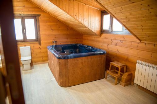 La salle de bains est pourvue d'une grande baignoire en bois et de toilettes. dans l'établissement La Casa del Cura Calao, à Valdepeñas