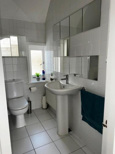 Baño blanco con lavabo y aseo en Apartment in Canford Cliffs close to Sandbanks Beach en Poole