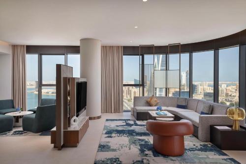 a living room with a couch and a tv at Conrad Bahrain Financial Harbour in Manama