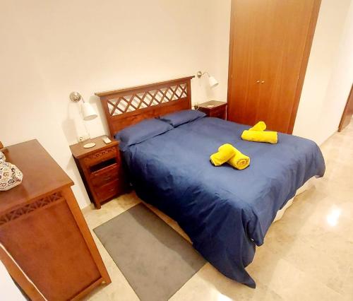 a bedroom with a bed with two yellow shoes on it at Awesome central house with 3 bedrooms in Ceuta