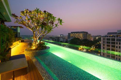 una piscina con un árbol en un edificio en COSI Vientiane Nam Phu en Vientián