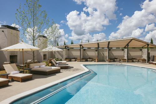 una piscina con sillas y sombrillas junto a un edificio en Drift Nashville, a Member of Design Hotels en Nashville