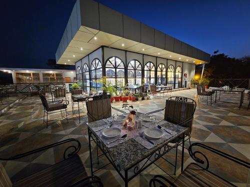 um pátio com uma mesa e cadeiras e um edifício em Hotel The Bundela - Khajuraho, Madhya Pradesh em Khajuraho