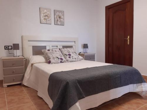 - une chambre avec un lit et une table de chevet avec deux lampes dans l'établissement Apartamento Turístico Lavanda, à Lumpiaque