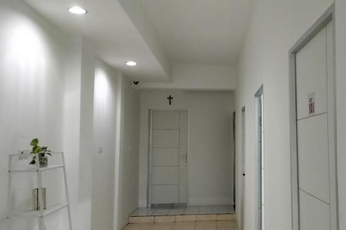 un corridoio con una porta e una croce sul soffitto di Cozy Home 2 RedPartner a Manado