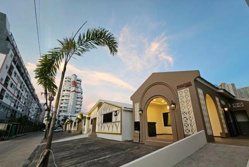 ein Gebäude mit einer Palme neben einer Straße in der Unterkunft Madaguscar PoolVilla-Pattaya in Jomtien Beach