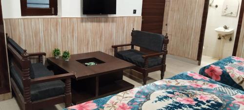 uma sala de estar com uma mesa de centro e um sofá em Hotel Host near Taj em Agra