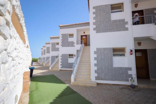 a row of buildings with stairs and a green floor at Andalusia Blue Beach Hurghada in Hurghada