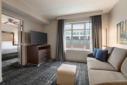 una camera d'albergo con divano, TV e letto di Homewood Suites by Hilton Washington, D.C. Downtown a Washington