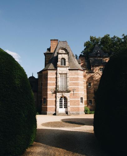 um antigo edifício de tijolos com uma janela e um telhado em La suite de la Mirande em Namur