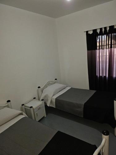 een slaapkamer met 2 bedden en een raam bij Confortable departamento in Guaymallen