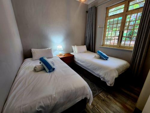 2 camas individuais num quarto com uma janela em M1 Umdloti Resort em Umdloti