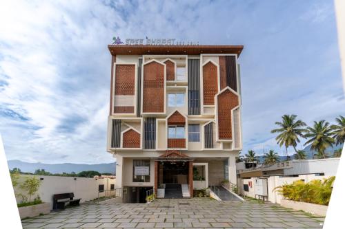 een gebouw op het strand met palmbomen bij Sree Bharat Residency in Alāndurai