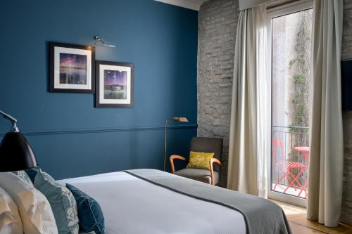 um quarto azul com uma cama e uma janela em The Fifteen Keys Hotel em Roma