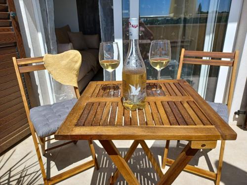 una mesa de madera con dos copas de vino. en Omega Apartments, en Premantura