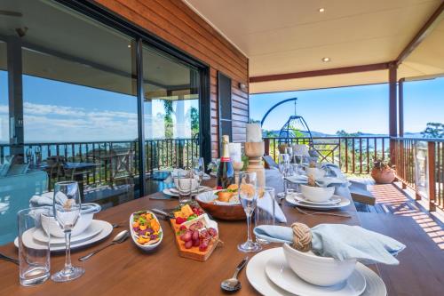 een eetkamer met een tafel met eten op een balkon bij Coral Sea Views in Airlie Beach