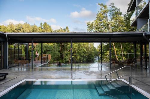 une maison avec une piscine aux parois en verre dans l'établissement Hestraviken Hotell & Spa, à Hestra