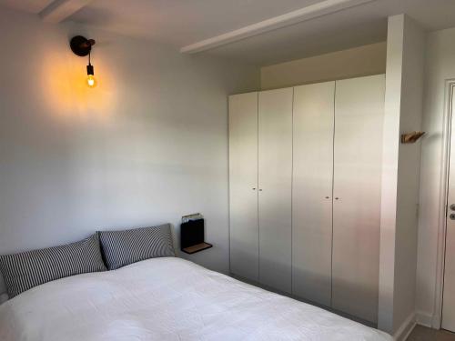 a bedroom with a bed and a white cabinet at Luxury Holiday Home With Sea View in Gråsten