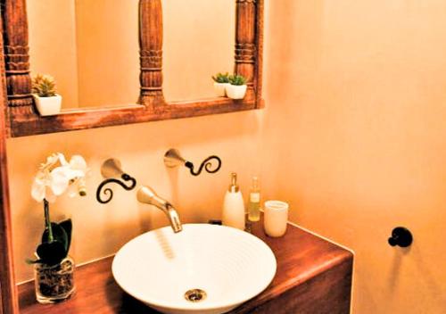 y baño con lavabo blanco y espejo. en Auwas Island Holiday Home en Burnt Pine