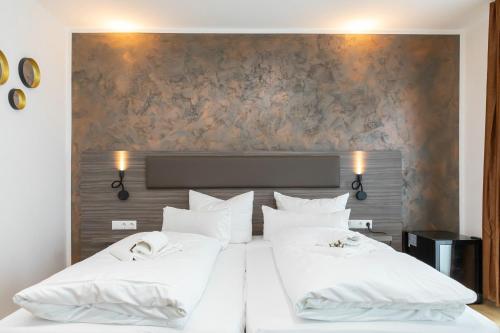 1 dormitorio con 2 camas y almohadas blancas en Central Hotel & Lounge Adult Only en Goslar