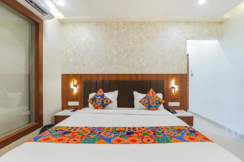 a bedroom with a large bed with colorful pillows at FabHotel Raj Palace in Lucknow