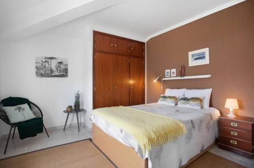 - une chambre avec un lit et une chaise dans l'établissement Porto Dinheiro Beach I, à Lourinhã