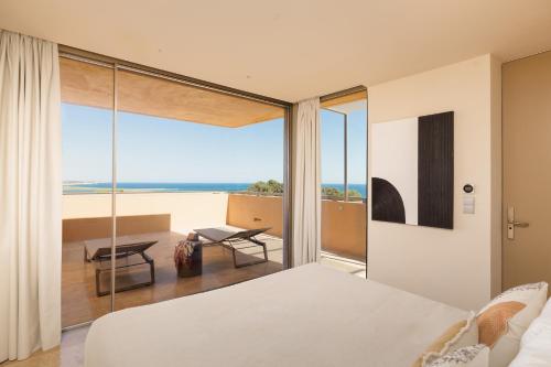 a bedroom with a bed and a view of the ocean at Palmares Signature Apartments in Lagos