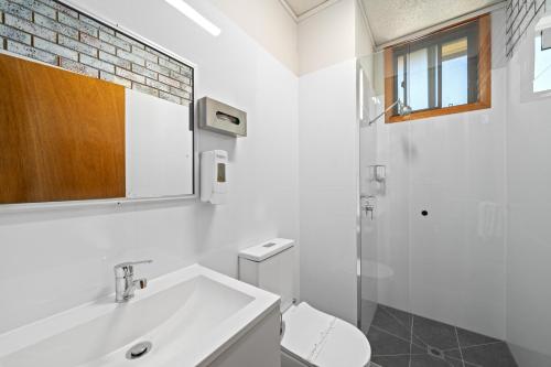 Baño blanco con lavabo y aseo en Comfort Inn Benalla, en Benalla