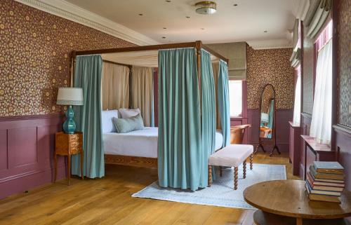 um quarto com uma cama e cortinas num quarto em The Mitre, Hampton Court em Kingston upon Thames