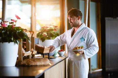 a man standing in a kitchen holding a plate of food at Thermae 2000 in Valkenburg