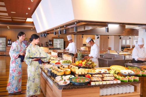 um grupo de pessoas em uma cozinha preparando comida em Ooedo Onsen Monogatari Premium Iseshima em Shima