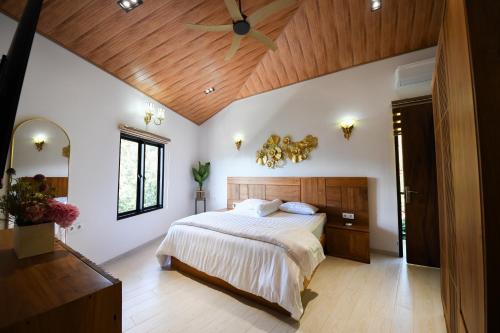 1 dormitorio con cama y techo de madera en Villa Casa de Monique en Bogor