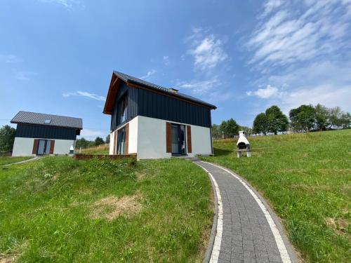 una casa en una colina con un camino en Domki Blisko Nieba I en Wisła