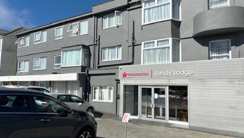 um carro estacionado em frente a um grande edifício em Magnuson Hotel Sandy Lodge Newquay em Newquay