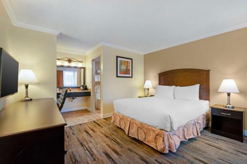 une chambre d'hôtel avec un lit et un bureau avec deux lampes dans l'établissement Best Western PLUS Burnaby Hotel, à Burnaby