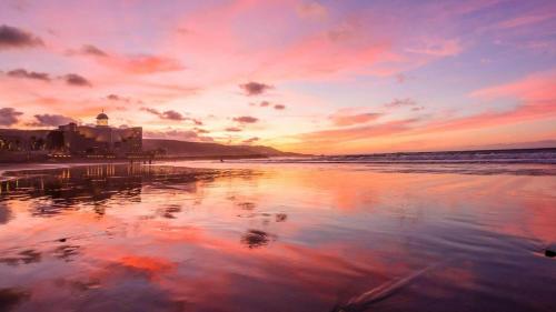 een zonsondergang op een strand met de oceaan bij Habitación cerca de Las Canteras in Las Palmas de Gran Canaria