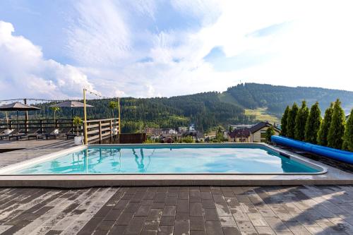 une grande piscine sur une terrasse avec une montagne dans l'établissement Comfort House, à Bukovel