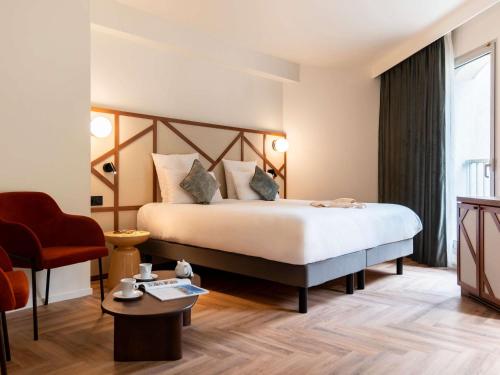 een hotelkamer met een bed en een stoel bij Mercure Rouen Centre Champ de Mars in Rouen