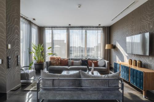 a living room with a couch and a tv at H15 Boutique Hotel, Warsaw, a Member of Design Hotels in Warsaw