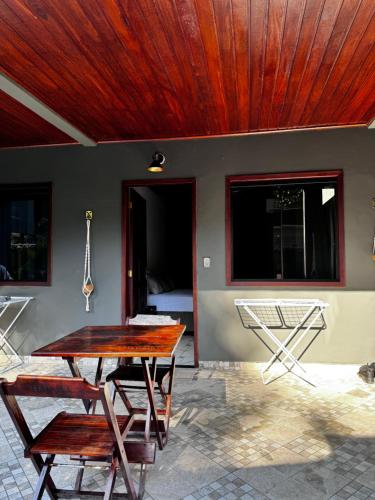 una mesa y sillas en un patio con techo de madera en BLUE DOOR BRASIL en Ilha Grande