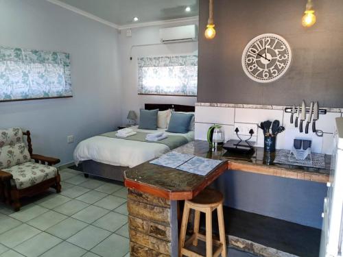 een slaapkamer met een bed en een keuken met een aanrecht bij Cherry Lane Guest House in Ficksburg