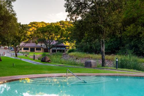 a swimming pool with a metal object in a park at ATKV Klein-Kariba in Bela-Bela